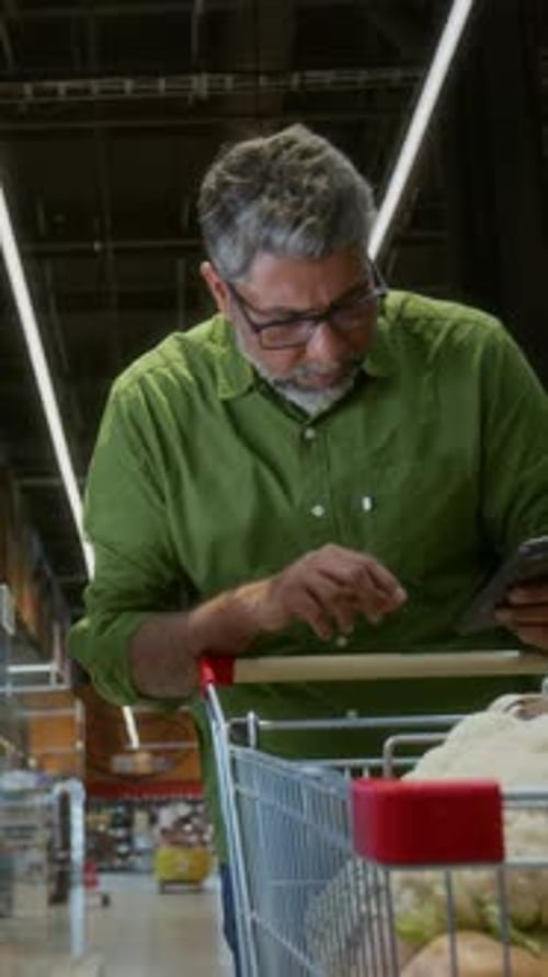 Mature Man Choosing Meats in Grocery Store
