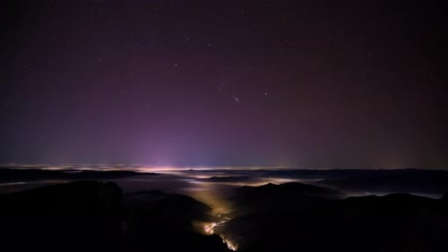 Night stars timelapse in the mountains with moving clouds. Ceahlau National Park, Romania
