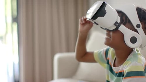 Excited Boy Using Virtual Reality Headset Indoors