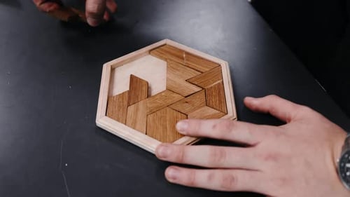 Ensamblar un rompecabezas de madera sobre una mesa en cámara lenta