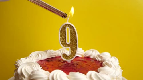 Lighting Candle on a Berry Birthday Cake
