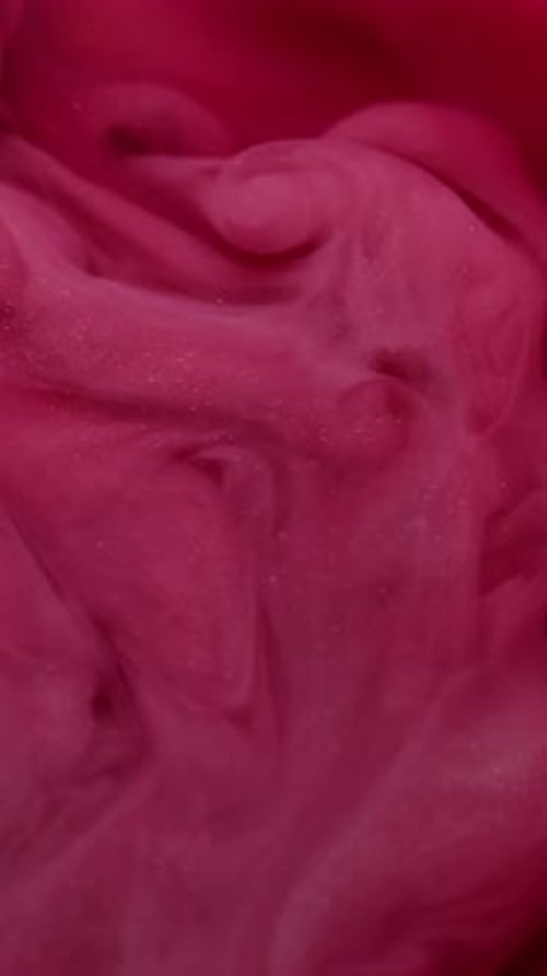 Glittering Pink Paint Swirling Slowly in Water
