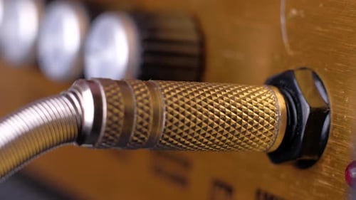 Hand inserts plug into amplifier close up