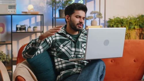 Man Video Conferencing From Home on Laptop