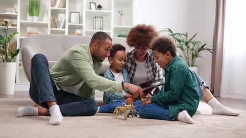 Cheerful Spouses and Two Carefree Preschoolers Resting on White Carpet