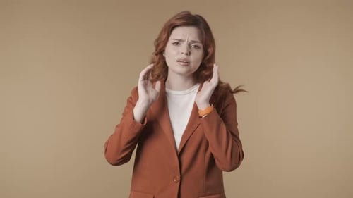 Woman Reacts to Loud Noise, Hands to Ears