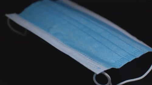 Light Blue Disposable Face Mask on Black Background