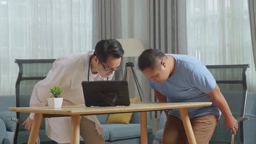 Male Doctor Working On Tablet Meets A Fat Male Patient In Clinic, Discussing About Medical Check Up
