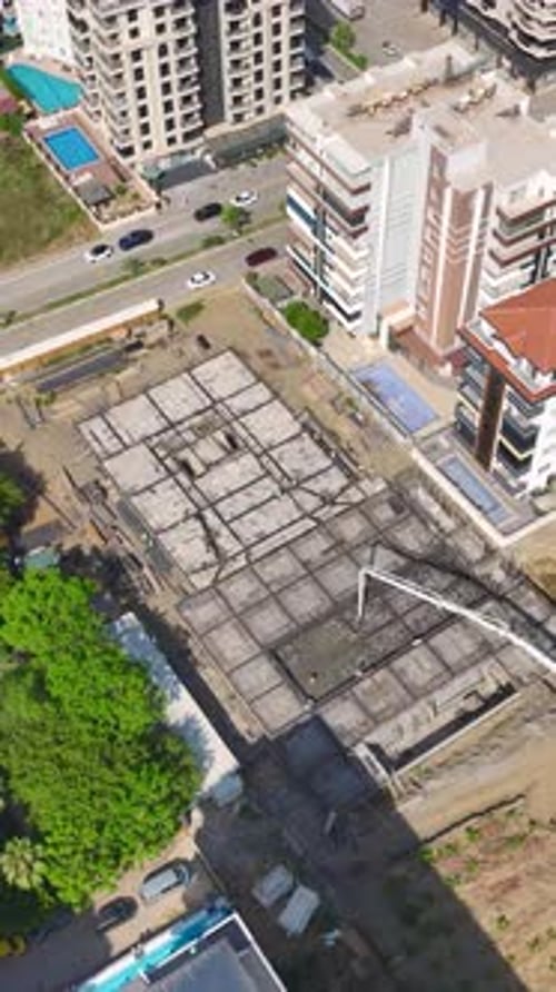 Vídeo vertical Los trabajadores colocan ladrillos y construyen paredes en una obra en construcción activa que avanza hacia