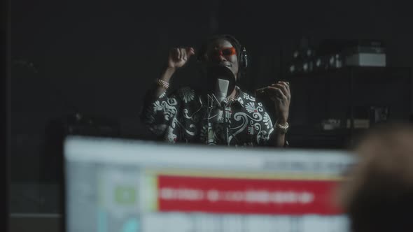 Black Rapper Singing in Recording Studio with Microphone and Headphones ...