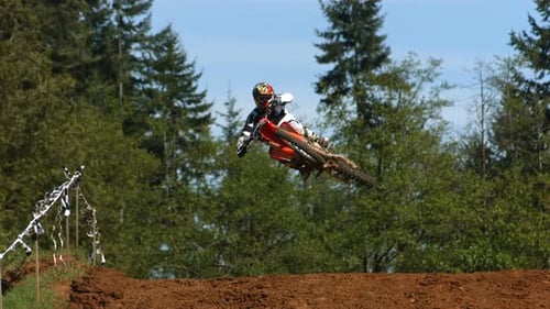 Motocross Rider Jumps High Over Dirt Hill