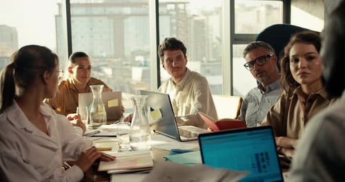 An Office Worker with Black Skin Color in a White Shirt Tells His Business Plan to Colleagues at the