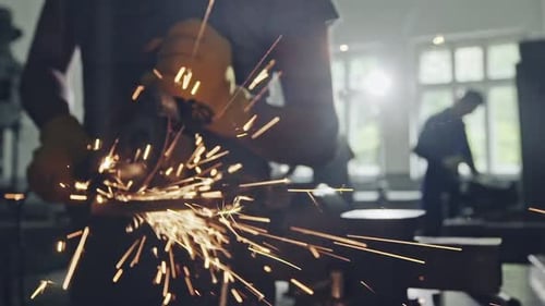 Man Cutting Metal with Angle Grinder Working Indoors in Workshop