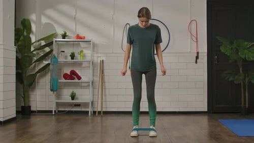 Woman doing resistance band leg exercise in studio