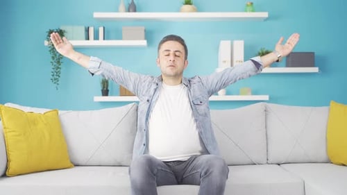 Man Meditating Indoors on Comfortable Couch