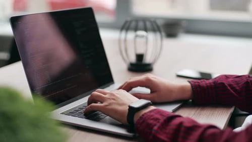 Nahaufnahme von Freelancers Händen, die Code auf der Laptop-Tastatur eingeben, rutscht um die des Entwicklers