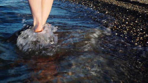 Female Legs Walking in Sea Water