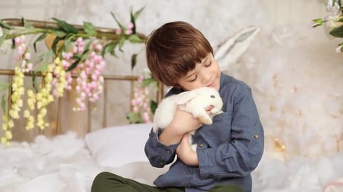 Boy Cuddles White Rabbit in Springtime Setting