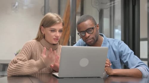 Adults Video Conferencing Using Laptop in Office