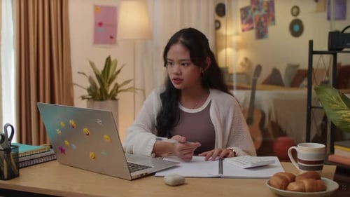 Asian Girl Giving Answer during Online Seminar Using Laptop from Home