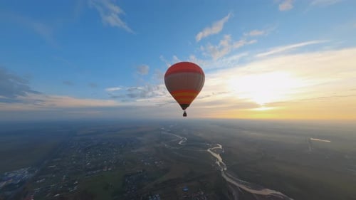 Birdseye View of Beautiful Colorful Hot Air Balloon Floating in Picturesque Evening Sunset Sky