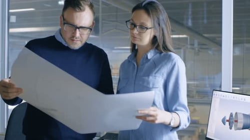 Female Industrial Engineer and Male Chief Engineer Work with Blueprints. CAD Software is Running on