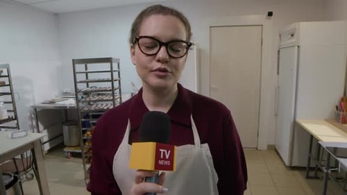 Woman with Microphone Speaking in Commercial Kitchen