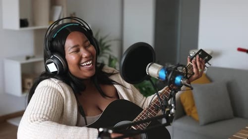 Woman Singing and Playing Guitar at Home