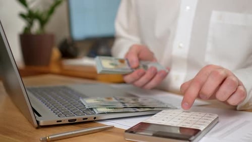 Homem segura um pacote de dólares Empresário de perto conta contas em dinheiro e calcula o lucro financeiro