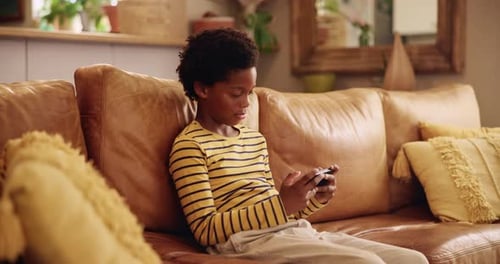 Child Looking at Cell Phone on Couch