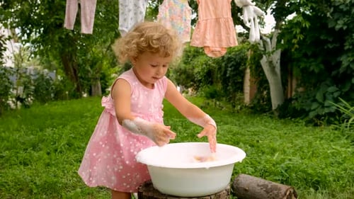The Child is Washing Clothes in the Garden Selective Focus