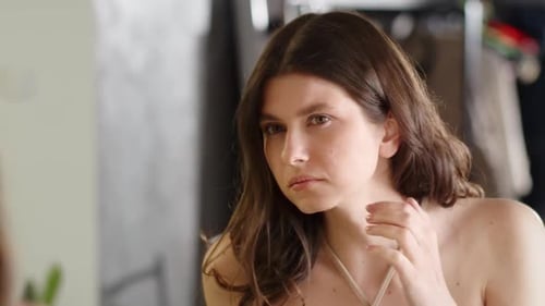 Woman Examines Face in Mirror Close Up