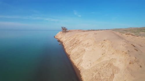 Desert Dune with Blue Sea at Sunrise