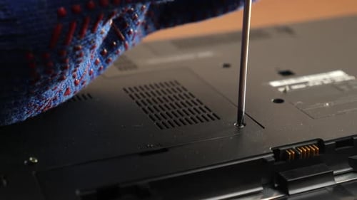 T96. The wizard removes the back cover of the laptop case. PC care and repair concept.