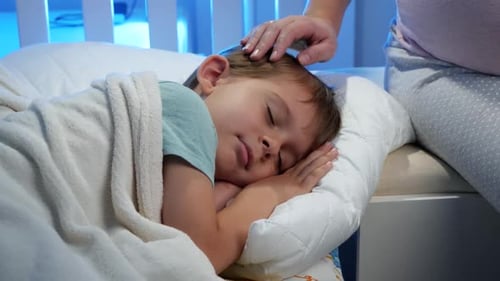 Child Sleeping Peacefully in Bed with Gentle Touch