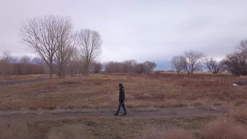 A man walks from a side trail to a paved path - sliding