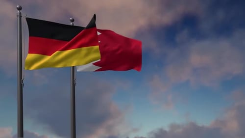 Germany and Bahrain National Flags Waving Against Cloudy Sky