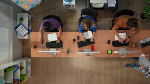 Call Center Top View of the Workers Talking with Clients Customers in Headset Typing on Computer
