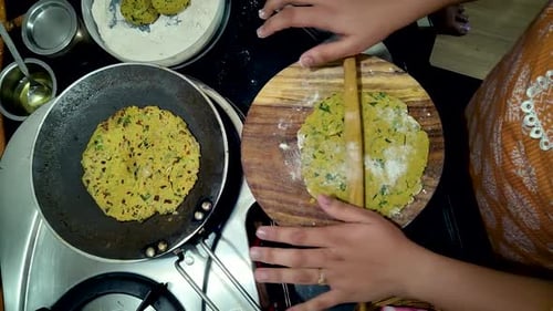 Indian woman making Gujarati thepla in home kitchen