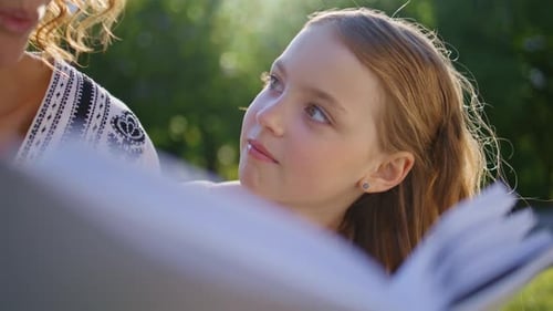Small Kid Watching Book Parent at Park Lawn Closeup Daughter Mother Resting