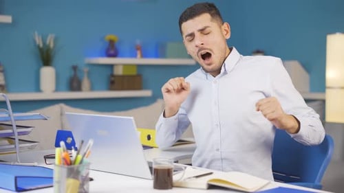 Un employé de bureau à domicile bâille et se détend devant la caméra.