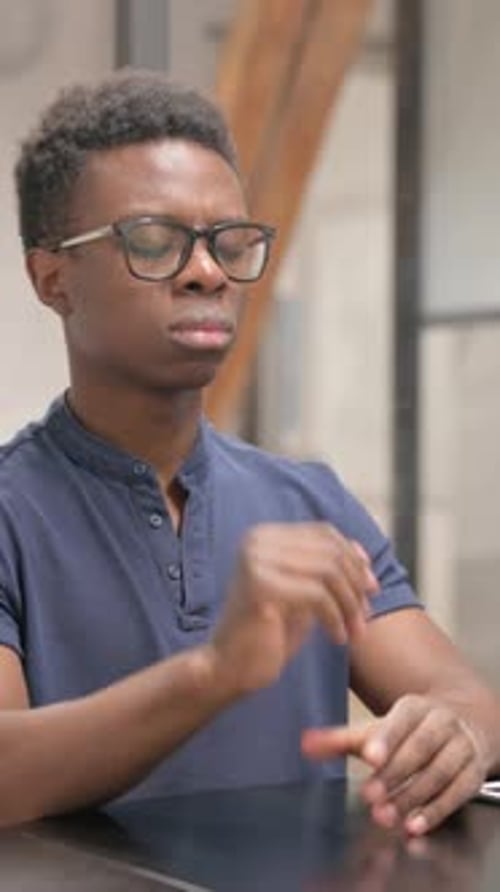 Young African Man with Headache in Office
