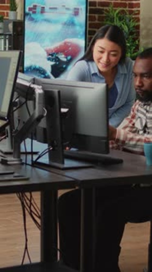 Video vertical: equipo multiétnico de empleados que desarrollan contenido 3D en software profesional