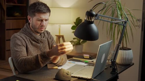 Man Sitting at Desk with Wrist Pain During Remote Work