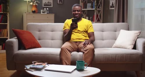 Young Adult on Couch Using Mobile Phone