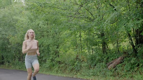 Girl Long Blonde Hair on a Morning Jog Running in the Forest Slow Motion