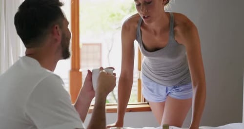 4k video footage of a young beautiful wife bringing her handsome husband breakfast in bed at home