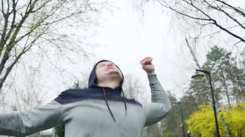 Man Celebrates Success Reaching Arms to Sky