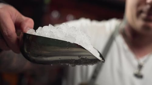 Person Scooping Crushed Ice into a Glass