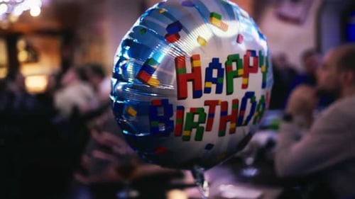 A Birthday Balloon Electric Blue Sits on a Table in a Restaurant
